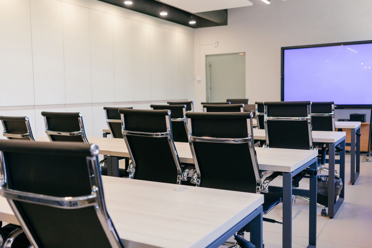 The Art of Drawing Readers In: Your attractive post title goes here Spacious, modern conference room with black chairs and a projection screen.