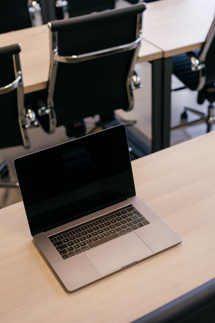 Mastering the First Impression: Your intriguing post title goes here A sleek office setting featuring a laptop on a desk and modern black chairs.